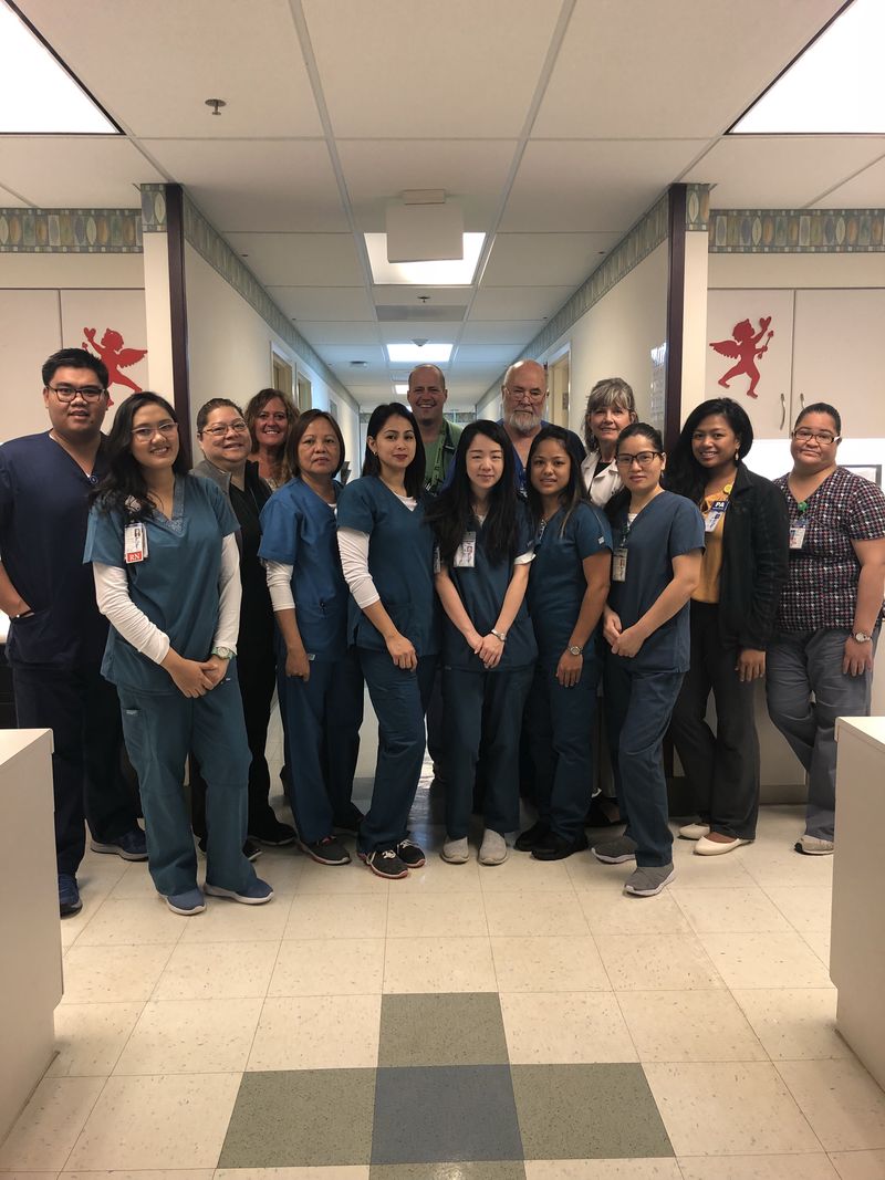 A group of CHCC staff in scrubs standing together in a hospital hallway